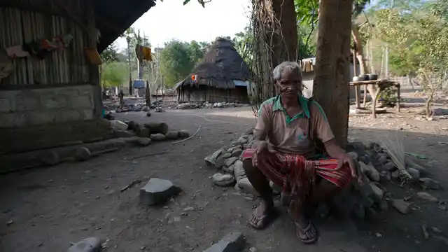 Laurencius Kollo, great-uncle of Marselina Neonbota, rests outside his home in Fatukoko village in West Timor, Indonesia.