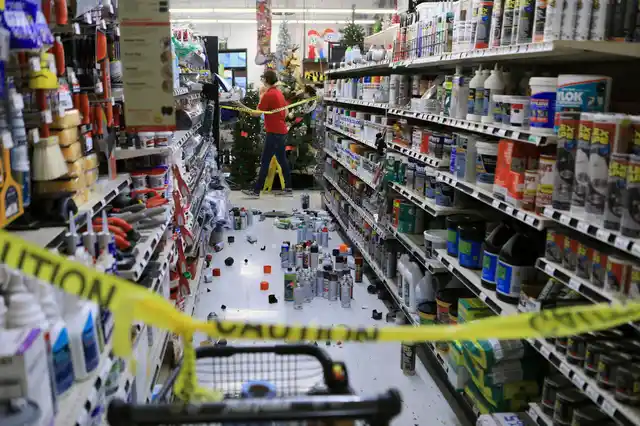 An employee walks past a damaged aisle at Anchorage True Value hardware store after the earthquake.