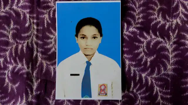 A photograph of Orance Faot dressed in her school uniform rests on a table in O’of Village in West Timor, Indonesia. 