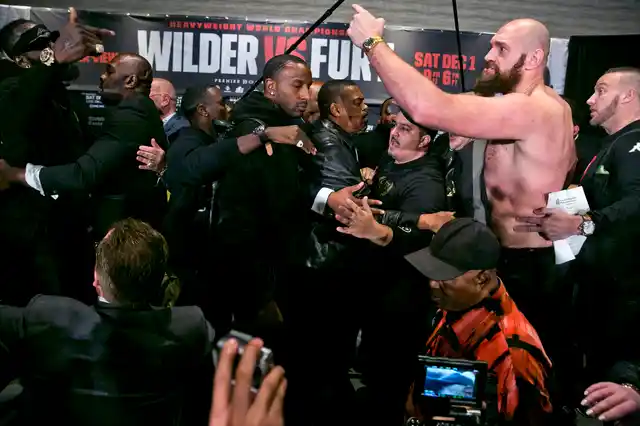 Boxers Deontay Wilder, far top left, and Tyson Fury, second from right, are separated by their respective team members after exchanging words at a news conference in Los Angeles, Wednesday, Nov. 28, 2018, ahead of their heavyweight world championship boxing match at Staples Center, on Dec. 1. 