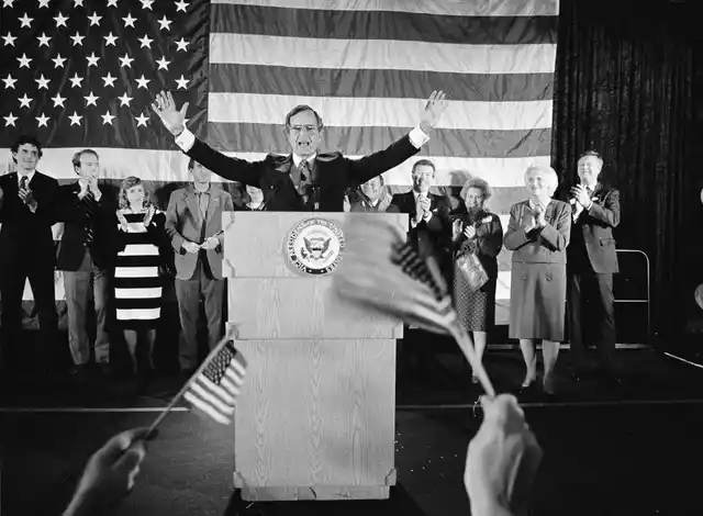 In this 1984 file photo, flag-wavers greet Vice President George Bush after he was re-elected to the post of vice president, in Houston, Texas. The vice president’s wife Barbara Bush is seen second from right.