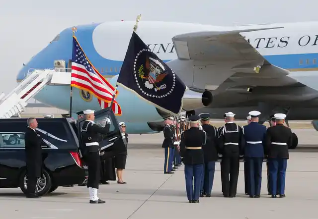 The flag-draped casket of former President George HW Bush is carried by a joint services military honor guard during a departure ceremony at Andrews Air Force Base.