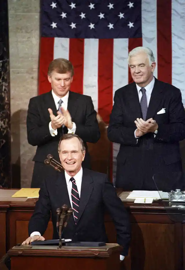 In this 1990 photo, President George HW Bush receives applause from Vice President Dan Quayle (left) and House Speaker Thomas Foley prior to delivering his first State of the Union address on Capitol Hill in Washington.