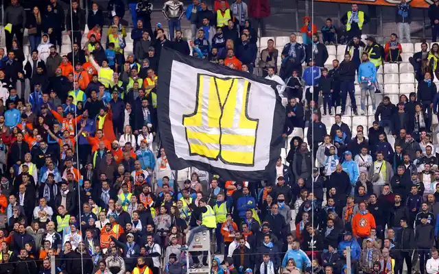 A supporter of Marseille waves a flag representing a giant yellow jacket, in solidarity with the movement of the demonstrators, called yellow jackets, who protest against the rising of the fuel taxes, during the League One soccer match between Marseille and Reims at the Velodrome stadium, in Marseille, southern France.