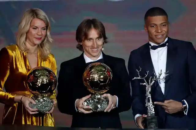 Real Madrid’s Luka Modric, with the Ballon d’Or, center poses with Olympique Lyonnais’ Ada Hegerberg with the Women’s Ballon d’Or, left, and Paris St Germain’s Kylian Mbappe with the Kopa Trophy.