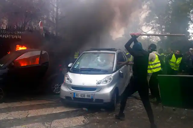 Hooded demonstrators smash a car during a demonstration on Saturday in Paris. 