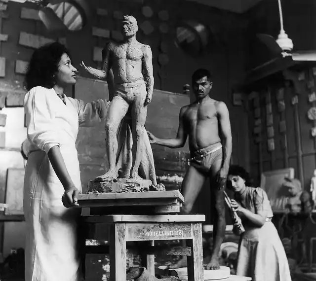 Rehana Mogul and Mani Turner at work in sculpture class at the J J School of Arts. A live male model can be seen inthe background. Bombay, late 1930s