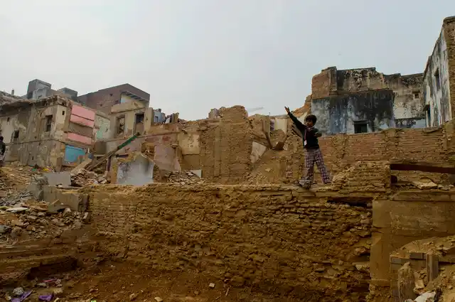 A boy plays alone at the demolition site.