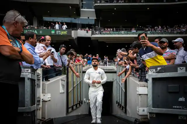 India captain Virat Kohli walks up the player race during play on Day 5 of the third cricket test between India and Australia in Melbourne, Australia, on Sunday, 30 December 2018. India won the Test to go up 2-1 in the four match series.
