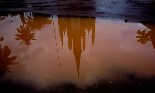 In this Saturday, 3 November, 2018, photo, the Immaculate Heart of Mary Cathedral is reflected in a puddle of water after a brief spell of rain in Kottayam.