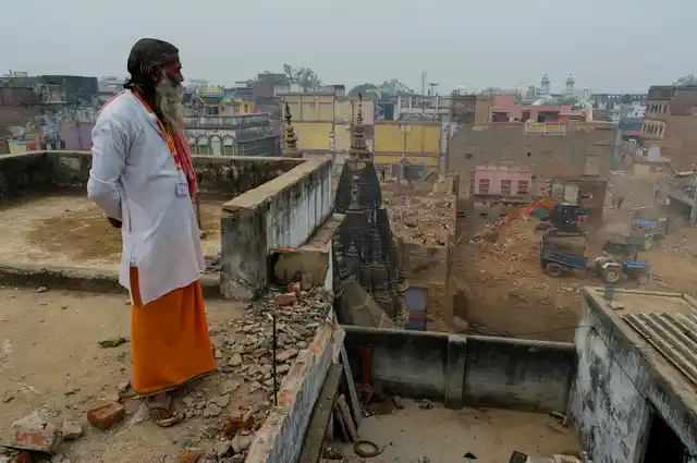 A contractor stands atop a house that he is assigned to demolish.