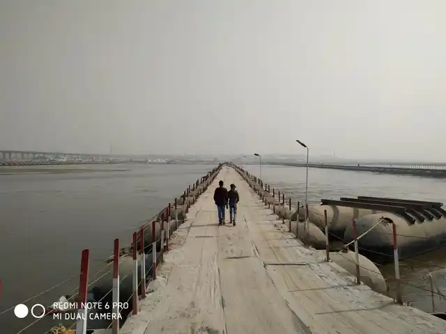 Men walk along a pontoon bridge, constructed especially for the Kumbh.