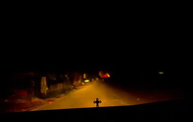 In this Thursday, 8 November, 2018, photo, a person drives in the night as a crucifix is seen on the dashboard in Kottayam