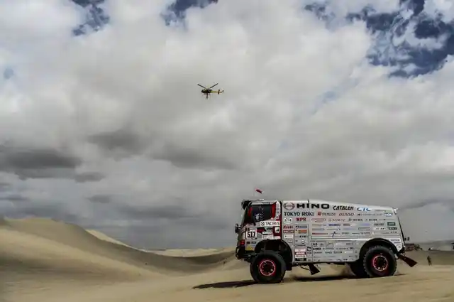 A truck during the race, as a rescue helicopter looks on.