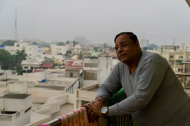 Padampati Sharma stands at the balcony of his new apartment at Mehmoorganj, some four kilometres away from his ancestral home.