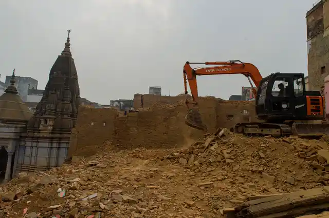 A temple stands in the background as the rubble is being cleared.