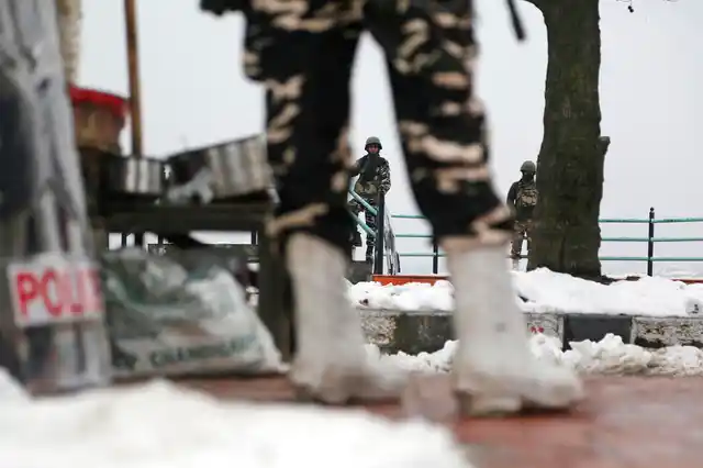 Paramilitary soldiers stand guard on a snow-covered street in Srinagar, on Monday, 7 January, 2019.