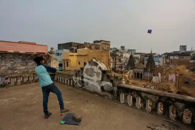 A boy flies a kite from atop a house at the area marked for the project.