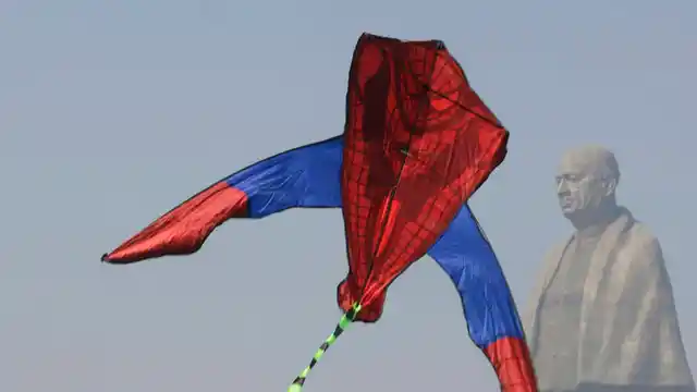 A kite flyer jumps with her kite near the Statue of Unity, the world’s tallest statue, during the International Kite Festival at Kevadiya Colony, on Tuesday, 8 January, 2019. Kite flyers from several countries are participating in the festival that is annually held on the Sabarmati riverfront.