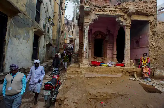 A sadhu sits in front of a damaged temple near Saraswati Phatak.