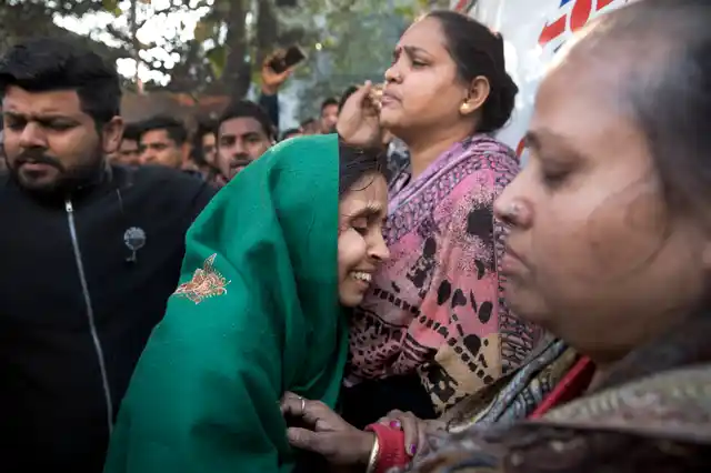 Unidentified relatives gather outside after an early morning fire at a hotel in the Karol Bagh. 