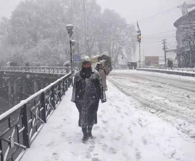 A man walks in a snowstorm in Srinagar.