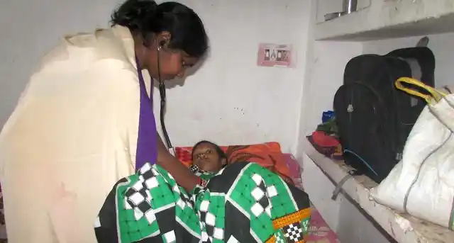 Maa Gruha coordinator Pushpita Sahu checks a pregnant woman staying at one of the maternity waiting homes .