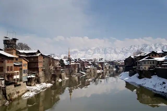 Snow-covered houses seen on the bank of the River Jehlum in Srinagar.