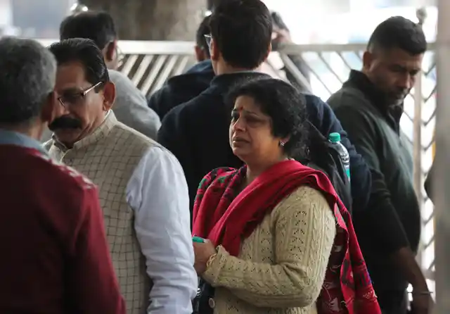 Unidentified relatives wait outside the mortuary to receive bodies of those who died in a hotel fire.