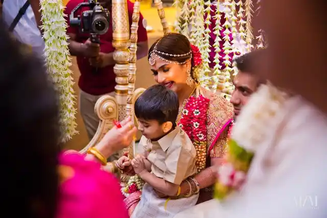 Soundarya’s son Ved sits on her lap as she sits on the oonjal as part <br>of the many Hindu traditions.