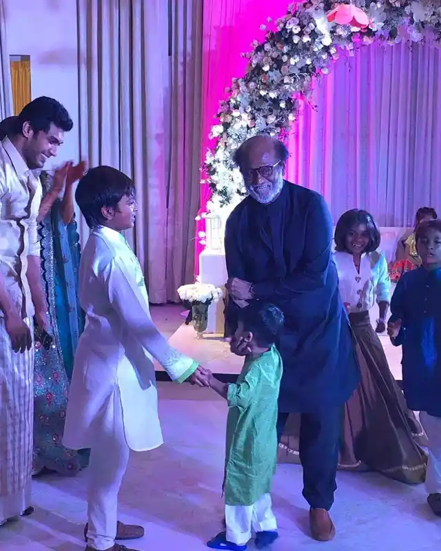 Superstar Rajinikanth playing with kids at the pre-wedding bash.