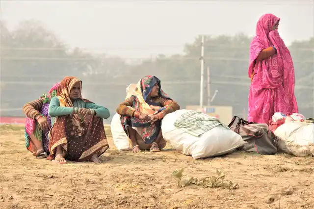 Women wait as their husbands try to figure out a way to cross over the river.
