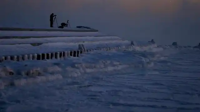 Photographers set up tripods along the shore of Lake Michigan before sunrise, Thursday, 31 January 2019, in Chicago. The painfully cold weather system that put much of the Midwest into a historic deep freeze was expected to ease Thursday, though temperatures still tumbled to record lows in some places.