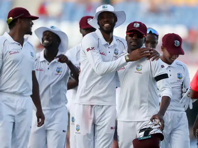 West Indies’ Roston Chase and Darren Bravo embrace at the end of their second innings against England during day three of the second Test cricket match at the Sir Vivian Richards Stadium in North Sound, Antigua and Barbuda, Saturday, Feb. 2, 2019. 