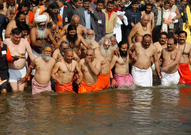 Uttar Pradesh CM Yogi Adityanath takes a holy dip accompanied by saints and cabinet colleagues at the Sangam, the confluence of rivers Ganges and Yamuna, during the Kumbh Mela in Prayagraj. 