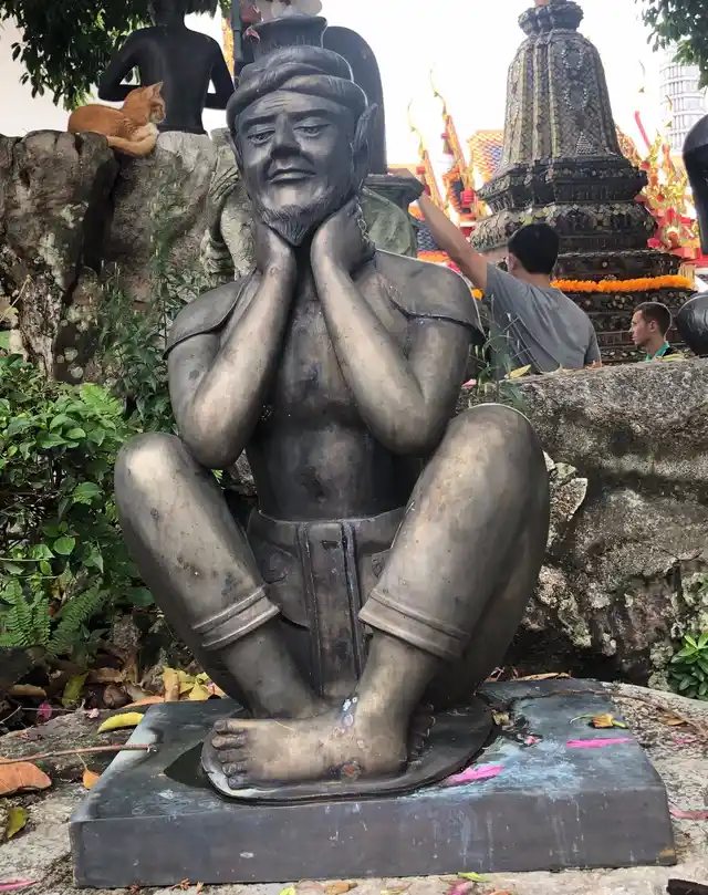 Statuette at the ‘Wat of Emerald Buddha’ is used to represent the author’s reluctant partner-in-crime.
