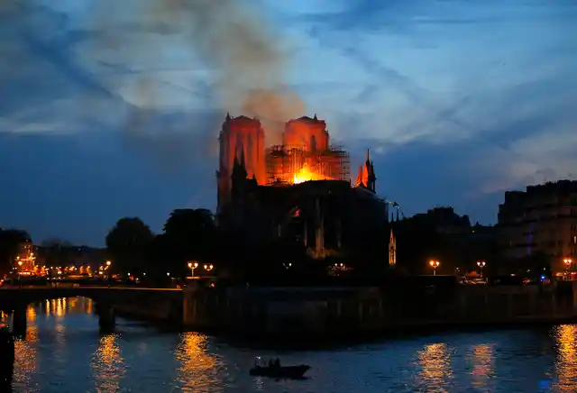 Firefighters tackle the blaze as flames and smoke rise from Notre Dame cathedral as it burns in Paris.