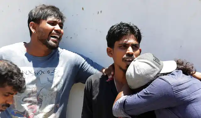 Relatives of people killed in church blasts mourn as they wait outside the mortuary of a hospital in Colombo, Sri Lanka on Sunday, 21 April.