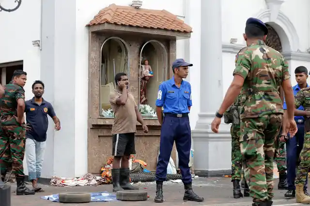 People gather outside St Anthony’s Shrine where a blast happened, in Colombo.