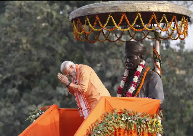 Prime Minister Narendra Modi greets the crowd as he stands in front of a statue of freedom fighter Madan Mohan Malviya at Banaras Hindu University in Varanasi.