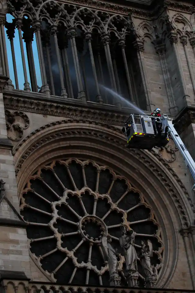 Fire fighter sprays liquid to control fire.