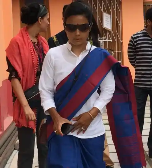 Mahua emerges in a red and blue Shantipuri saree, paired with a crisp, white t-shirt.