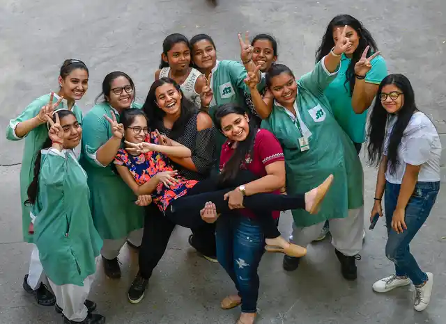Students display the victory sign after the Central Board of Secondary Education (CBSE) declared the Class 10 result in New Delhi.