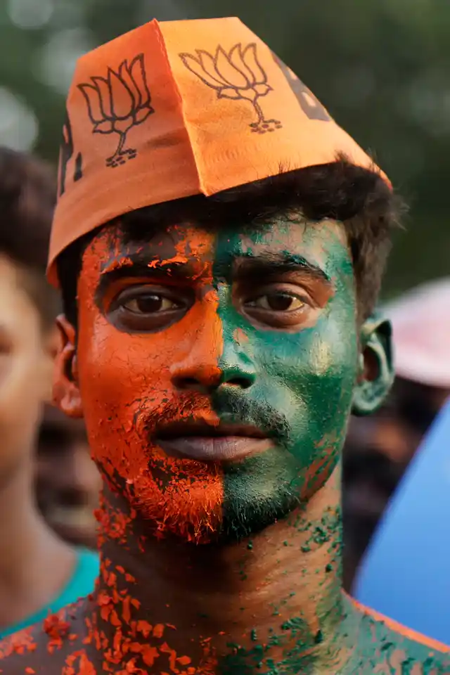 A supporter of the Bharatiya Janata Party stands with his body painted as he attends an election rally addressed by Prime Minister Narendra Modi, in Mathurapur. 