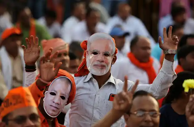 Bharatiya Janata Party (BJP) supporters wear masks of Prime Minister Narendra Modi and Uttar Pradesh Chief Minister Yogi Adityanath during an election rally in Prayagraj, India, Monday, 29 April 2019. 