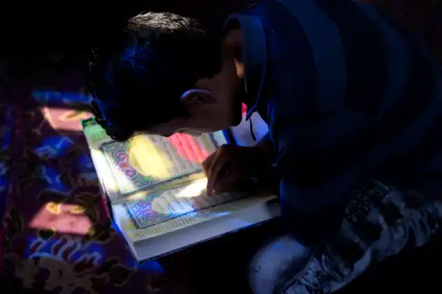 A Kashmiri boy reads verses from the Holy Quran inside the shrine of Sufi saint Shiekh Abdul Qadir Jeelani during the holy fasting month of Ramadan in Srinagar. 