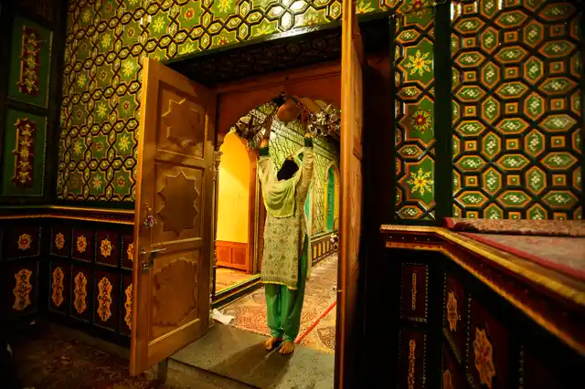 A woman prays at the entrance of a shrine on the first day of fasting month of Ramzan in Srinagar. Muslims across the world are observing the holy fasting month of Ramzan.