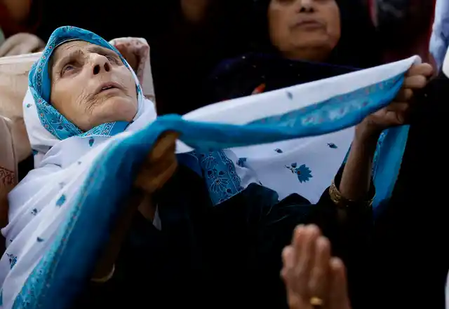 Kashmiri Muslim devotees pray as a head priest displays a relic believed to be of the Prophet Muhammad at the Hazratbal shrine, in Srinagar.