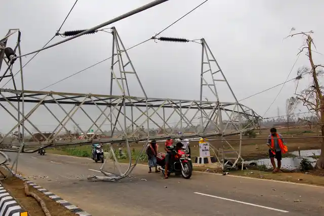 Commuters ride past damage caused by Cyclone Fani in Odisha. A mammoth evacuation of more than a million people spared India a devastating death toll from one of the biggest storms in decades.