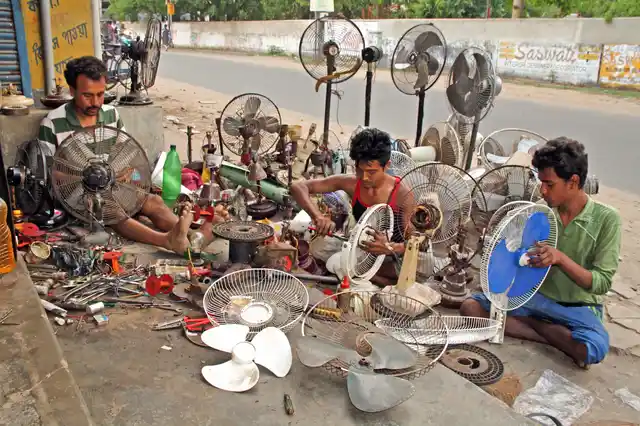 Workers repair fans at a roadside shop during the summer season, at Bolpur in Birbhum district of West Bengal.